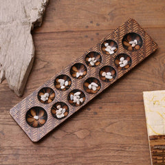 Batik Wood Game Five to Seven Stones and The Game is Played in Turns. Similar to Mancala, Each Player Collects the Stones From One Hole
